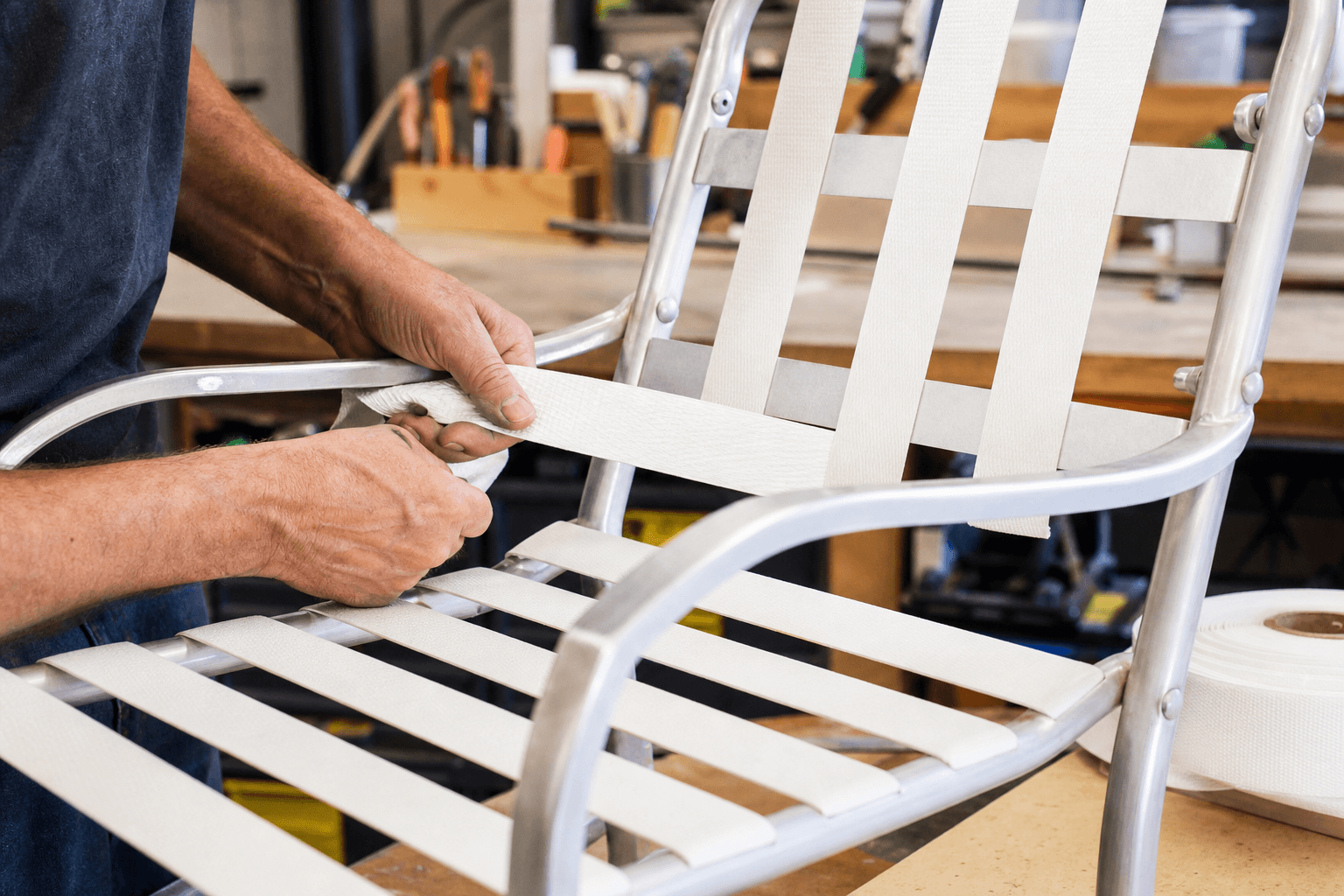 Close-up of a skilled technician installing high-quality patio furniture vinyl straps, showcasing the durability and craftsmanship in a Pompano Beach context
